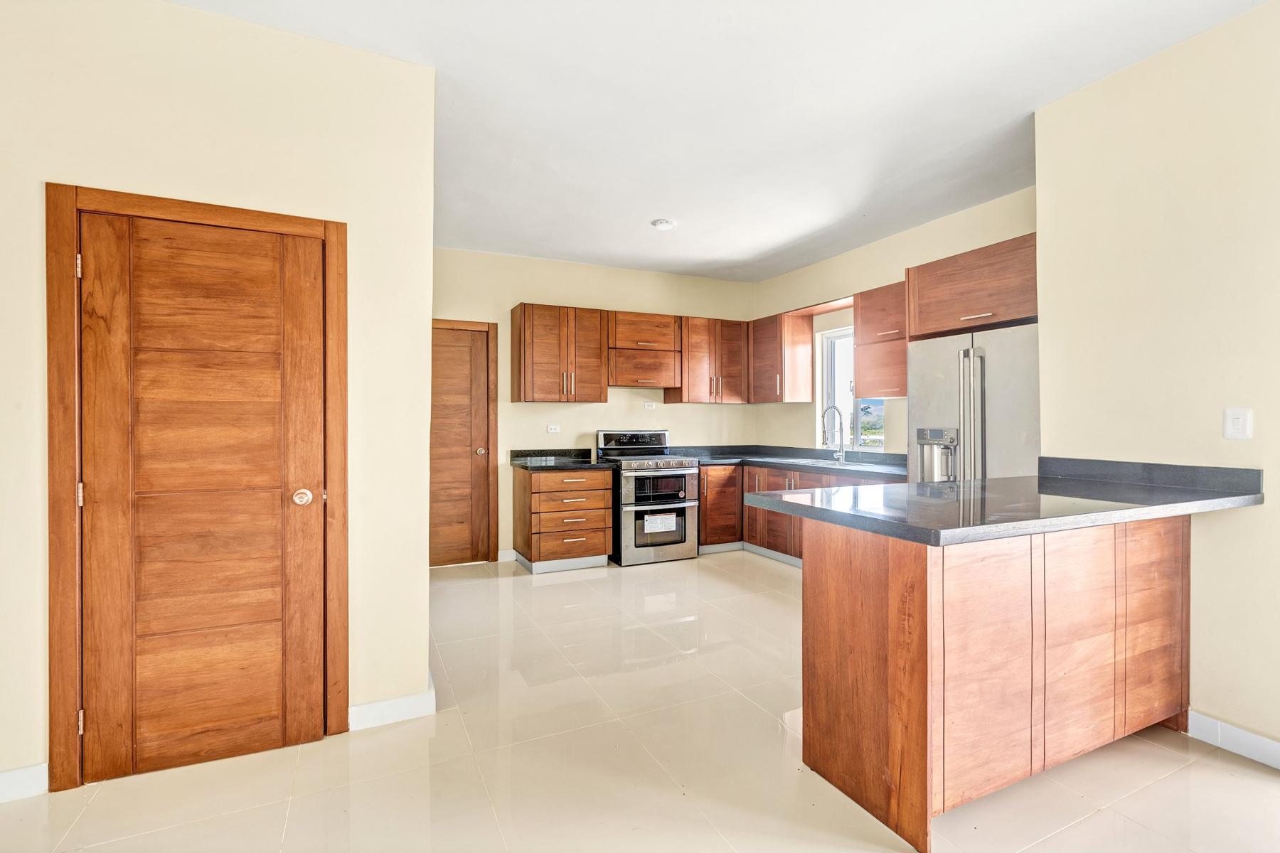Cocina con gabinetes de madera y tope de granito