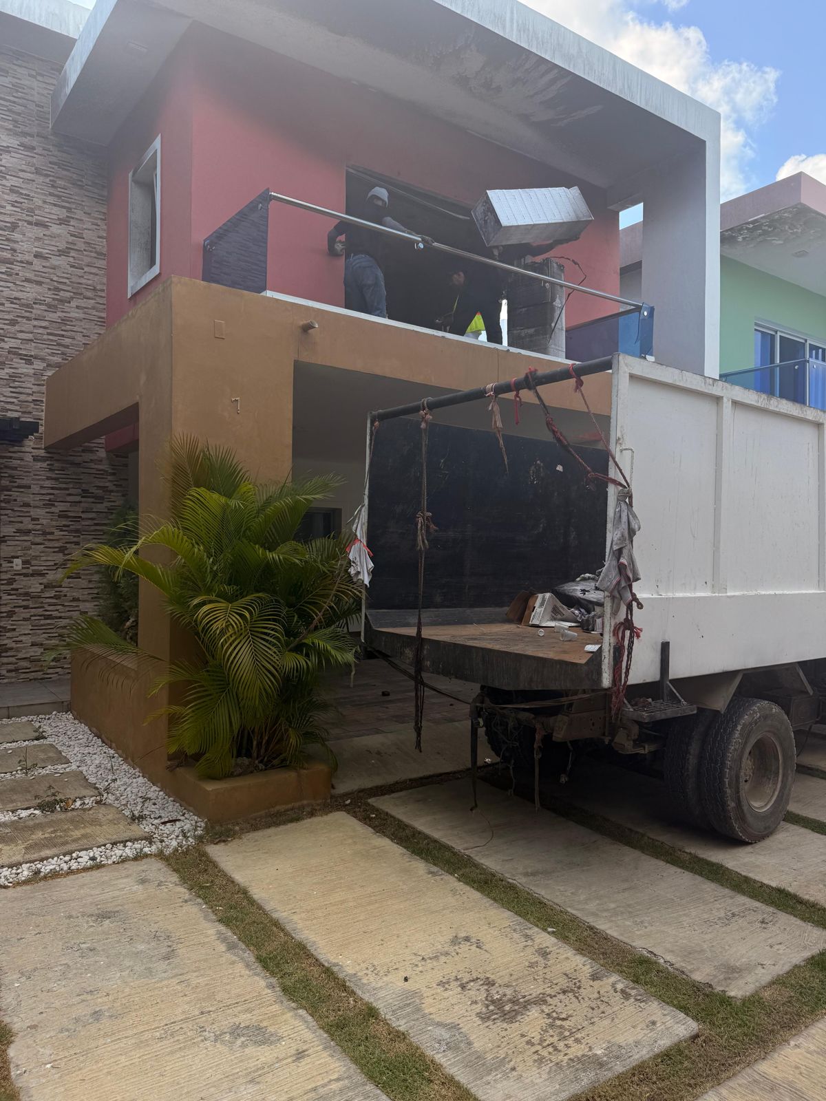La misma casa antes de la reparación, con el camión retirando escombros
