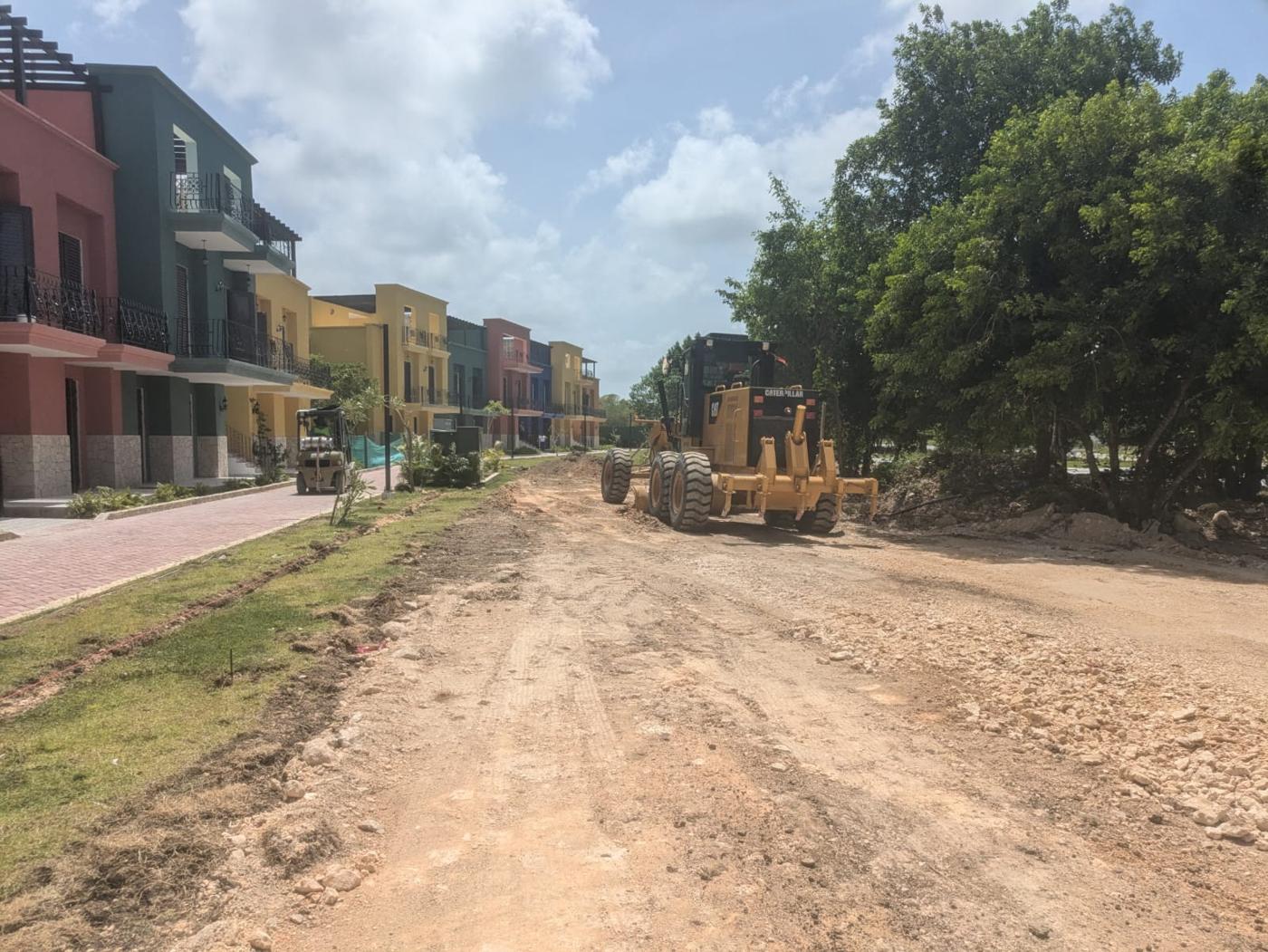 Motoniveladora perfilando una vía en un proyecto residencial